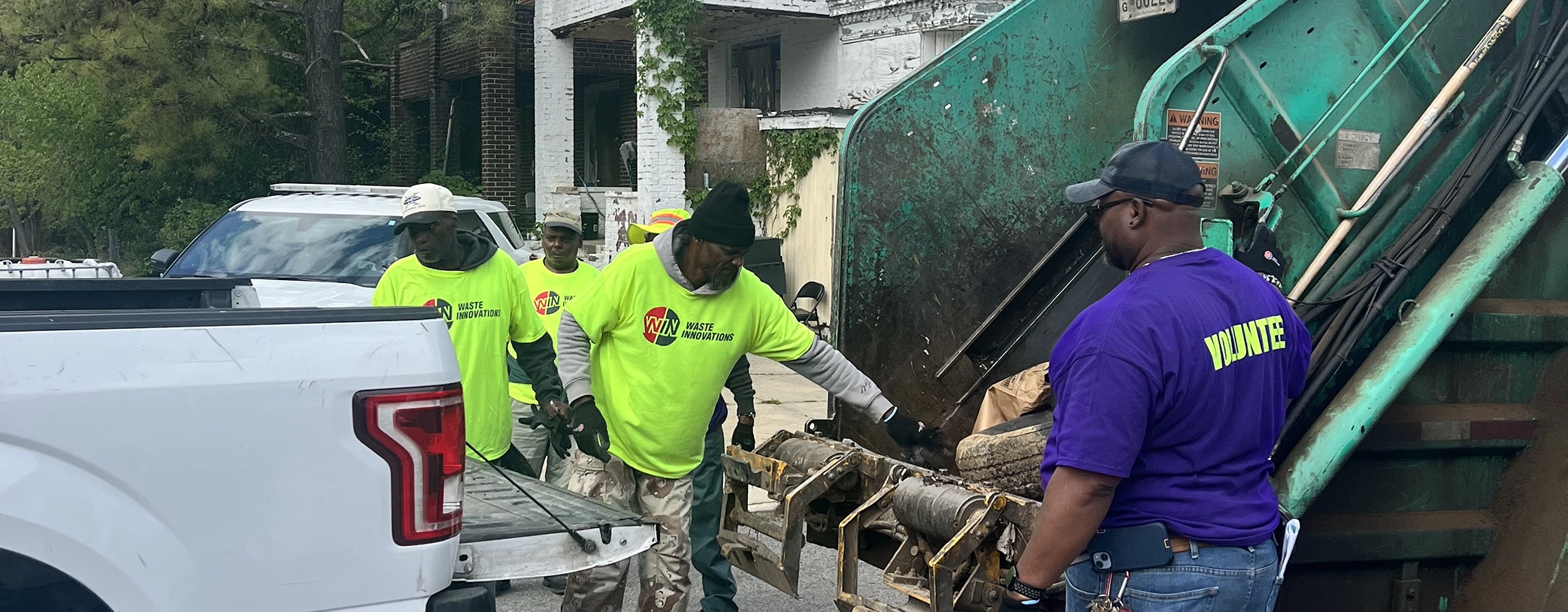 WIN volunteers loading trash they collected into a trash truck at an Earth Day cleanup event with the Mayor's office in Baltimore, MD